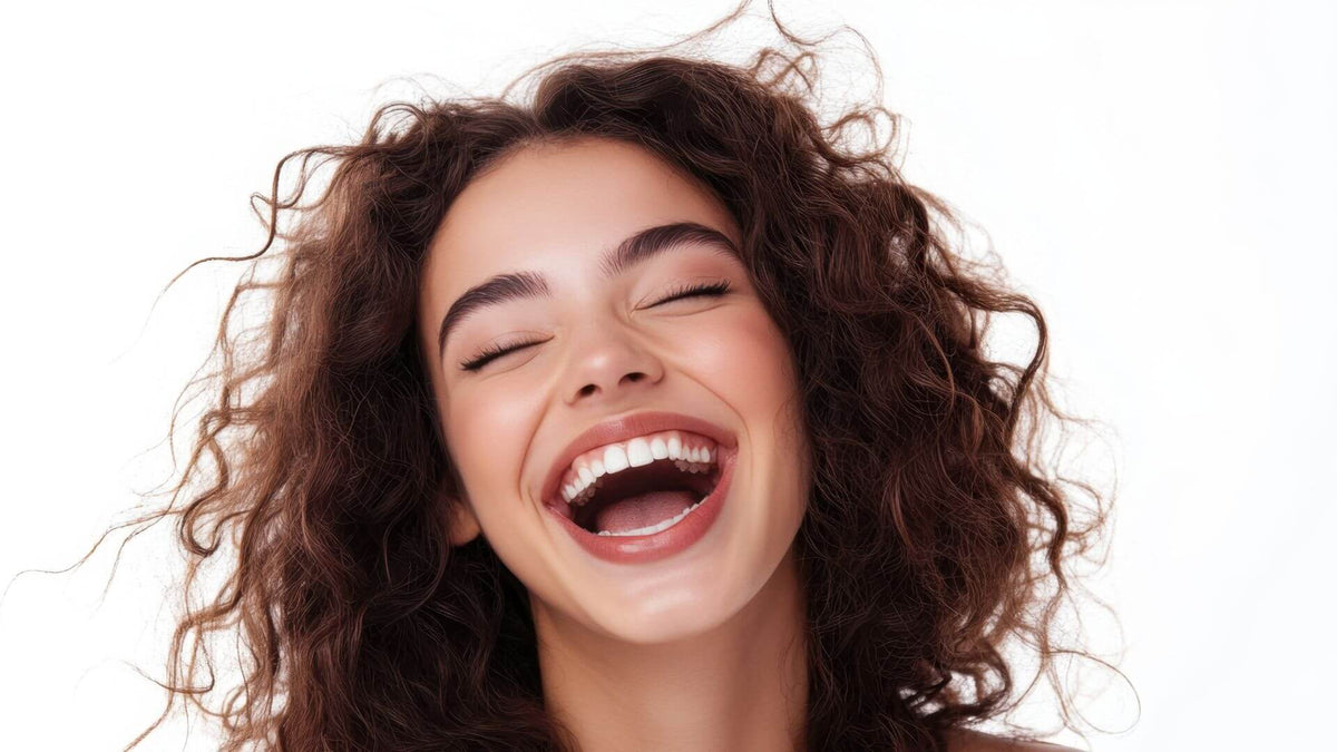 woman with curly brunette hair laughing