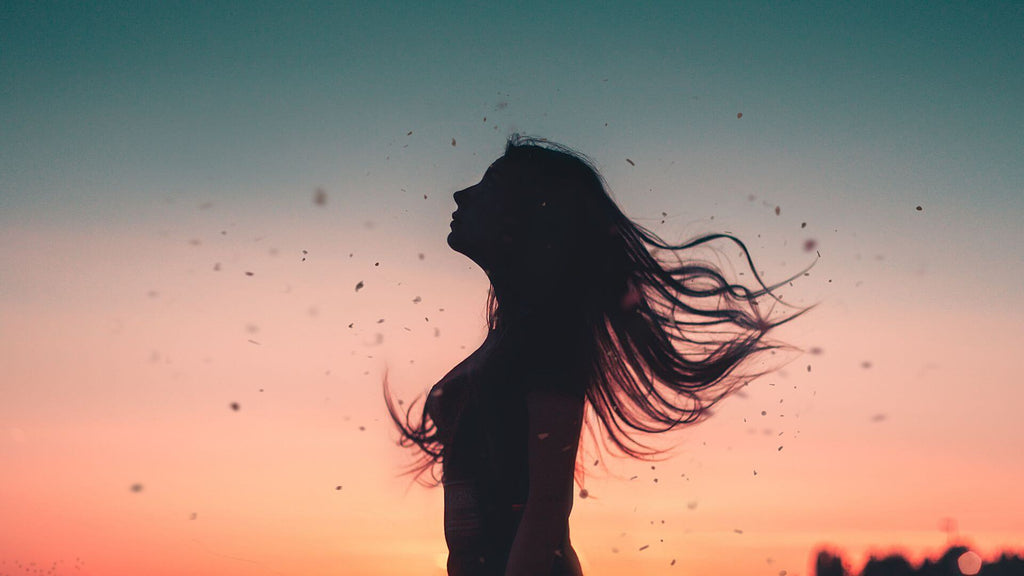 woman flipping hair in sunset