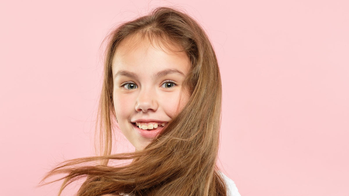 young girl with long hair pink background