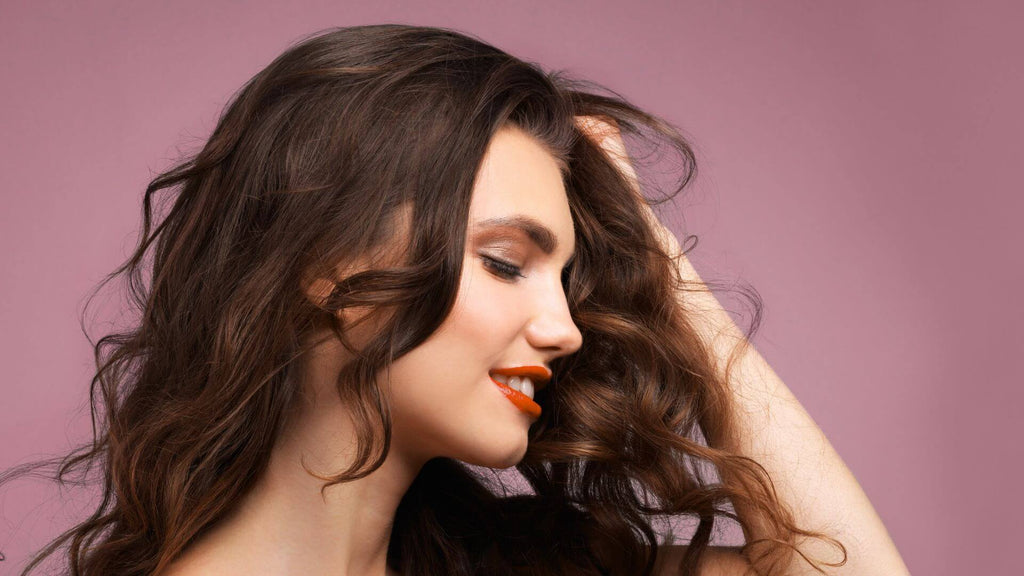 woman with brunette wavy hair purple background
