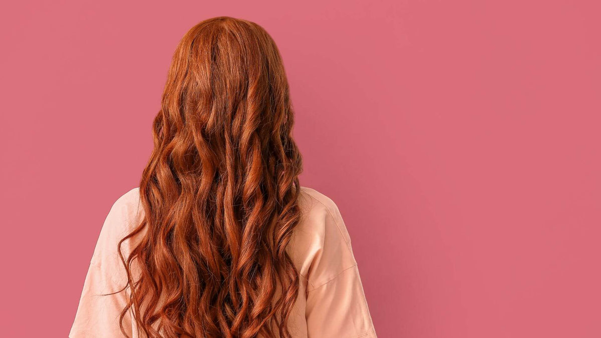 woman with red hair pink background