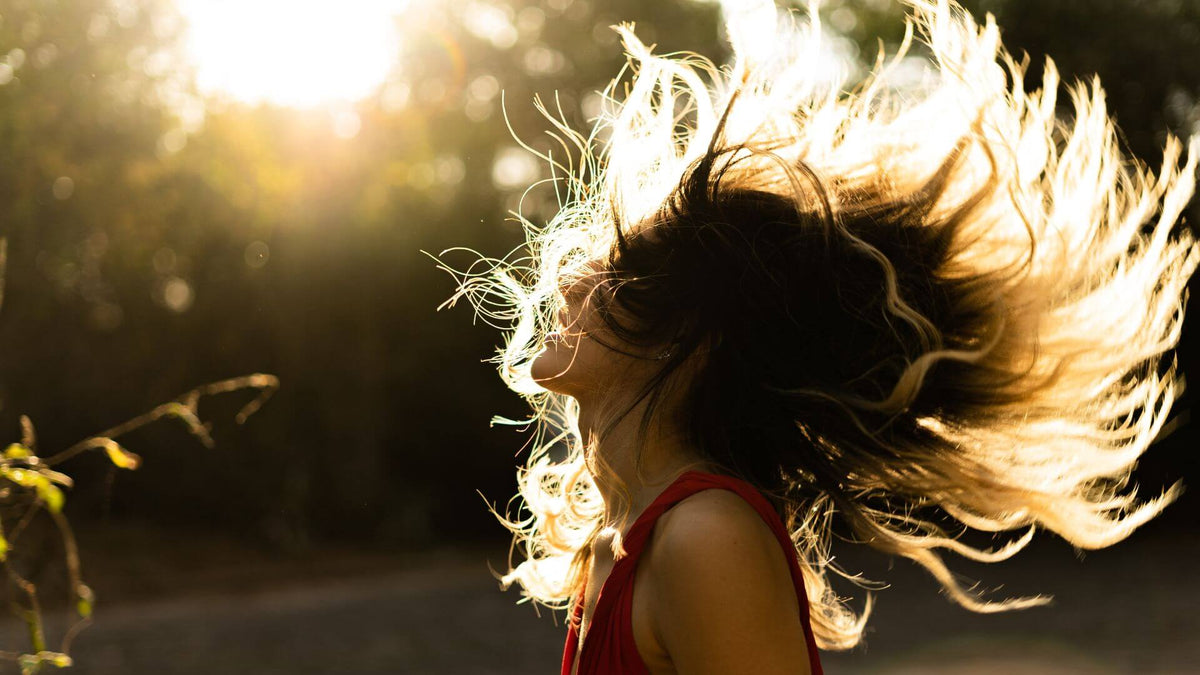 woman flipping hair in sun