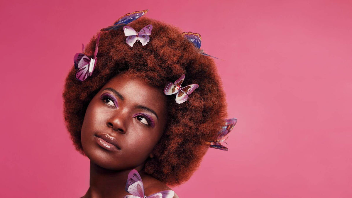 woman with afro butterflies pink background