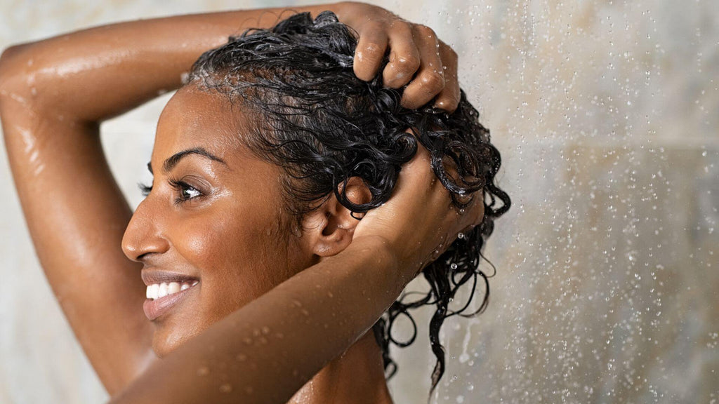 woman washing curly brunette hair