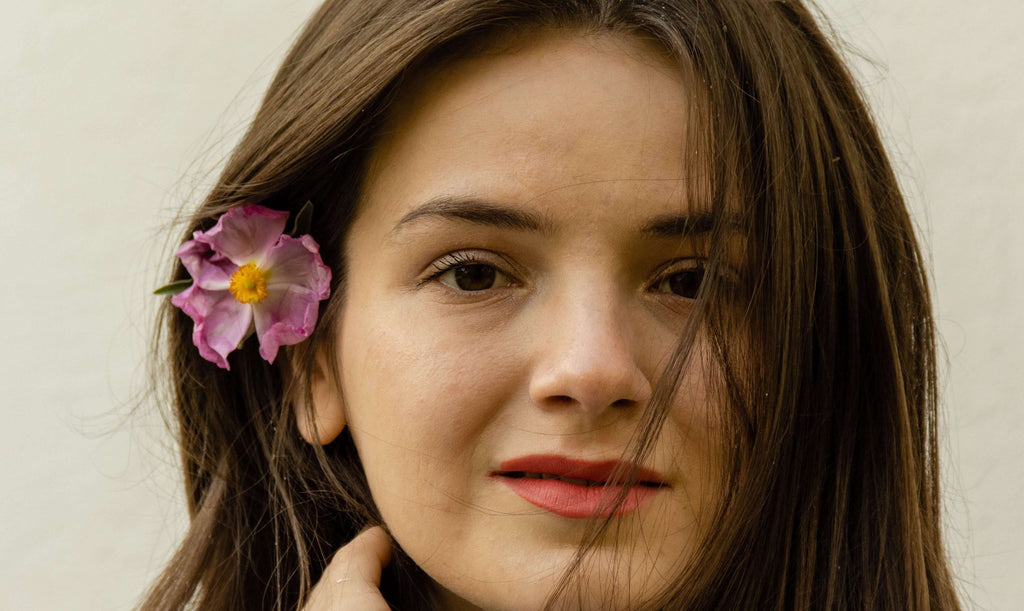 brunette woman with pink flower in hair